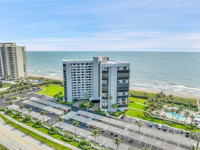 birds eye view of property featuring a water view and a beach view