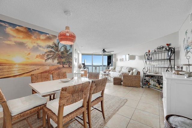 dining area with a textured ceiling, ceiling fan, and light tile patterned floors