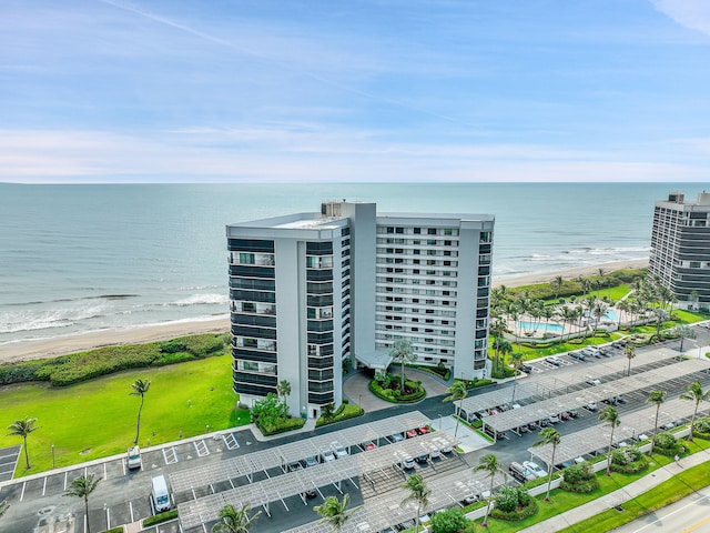 birds eye view of property with a water view and a beach view