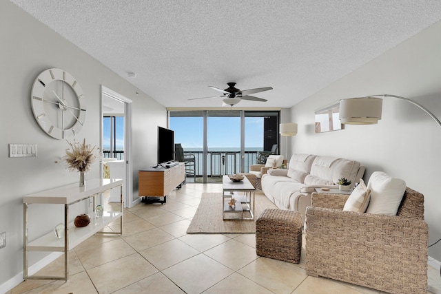 living room featuring floor to ceiling windows, a textured ceiling, ceiling fan, and light tile patterned floors