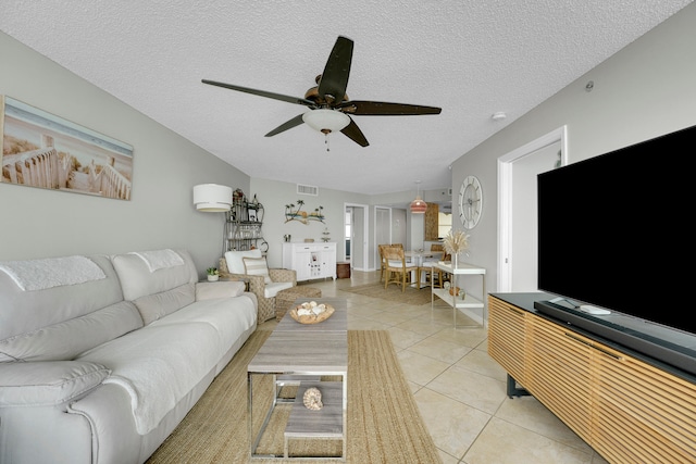 tiled living room featuring a textured ceiling and ceiling fan