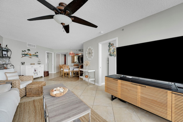 tiled living room with a textured ceiling and ceiling fan