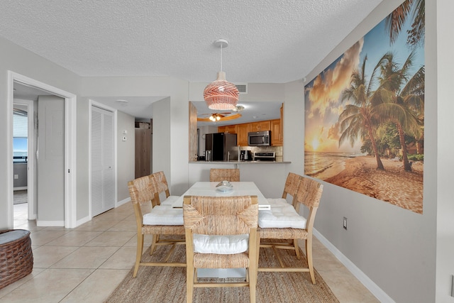 dining area featuring a textured ceiling and light tile patterned floors