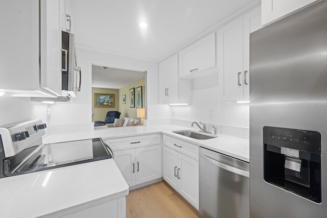 kitchen with sink, white cabinets, light hardwood / wood-style flooring, and stainless steel appliances