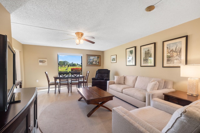 living room with ceiling fan and a textured ceiling