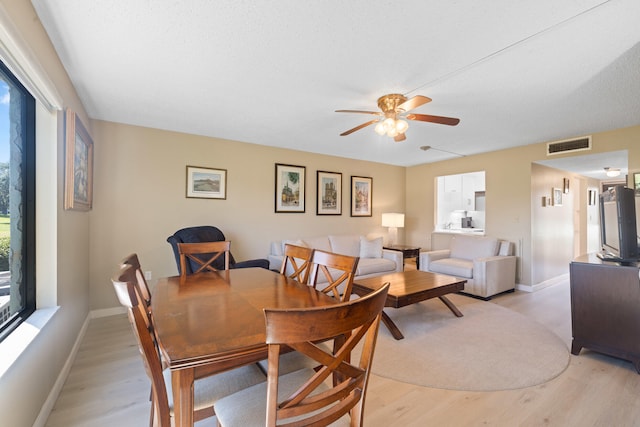 dining area with light wood-type flooring and ceiling fan