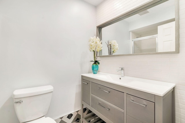 bathroom featuring vanity with extensive cabinet space, toilet, and tile walls