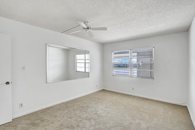 spare room featuring a textured ceiling, carpet, and ceiling fan