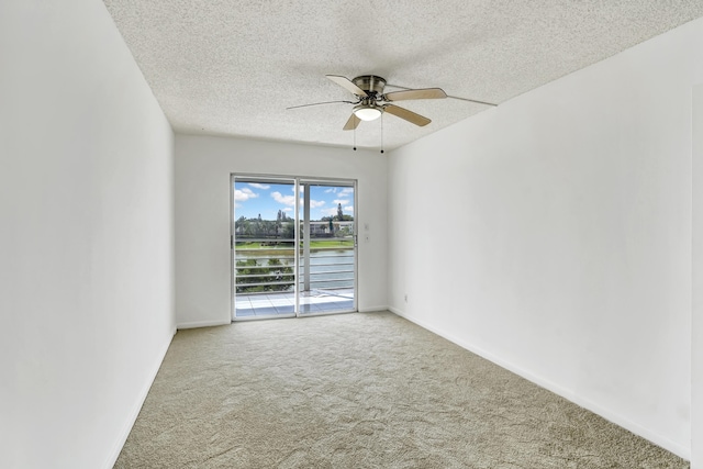 carpeted spare room with a textured ceiling and ceiling fan