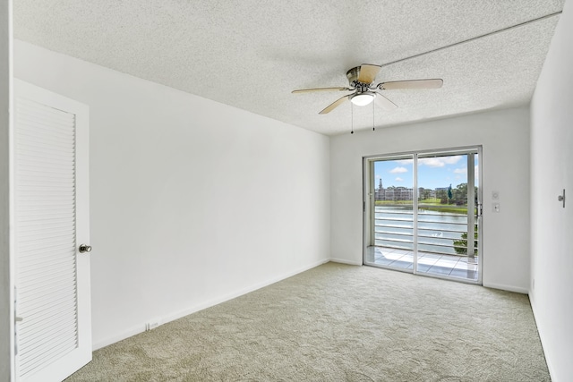 unfurnished room with a textured ceiling, carpet, and ceiling fan