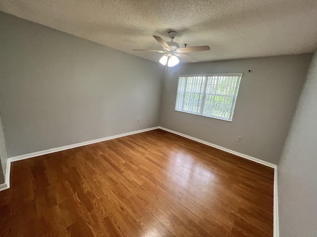 empty room with hardwood / wood-style flooring, ceiling fan, and a textured ceiling