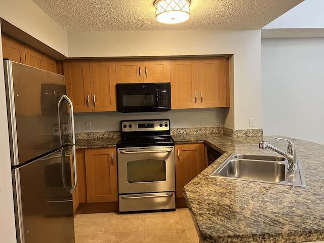 kitchen with sink, stainless steel appliances, kitchen peninsula, a textured ceiling, and light tile patterned floors