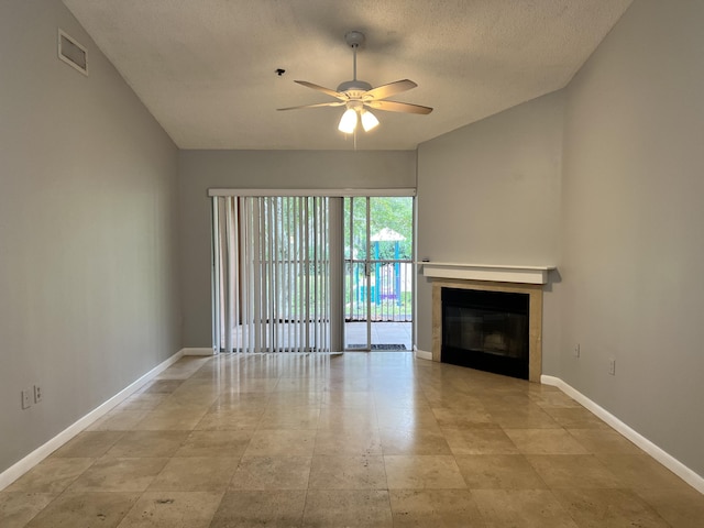 unfurnished living room with ceiling fan and a textured ceiling