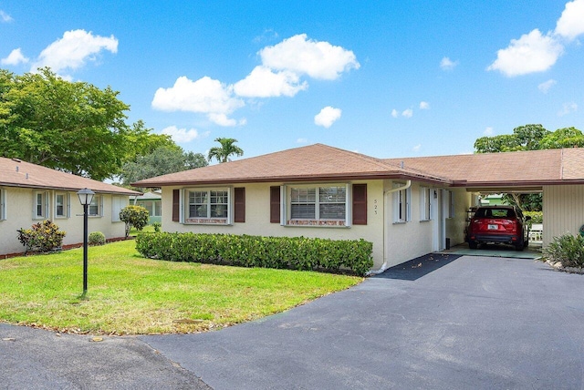 ranch-style home featuring a front yard and a carport