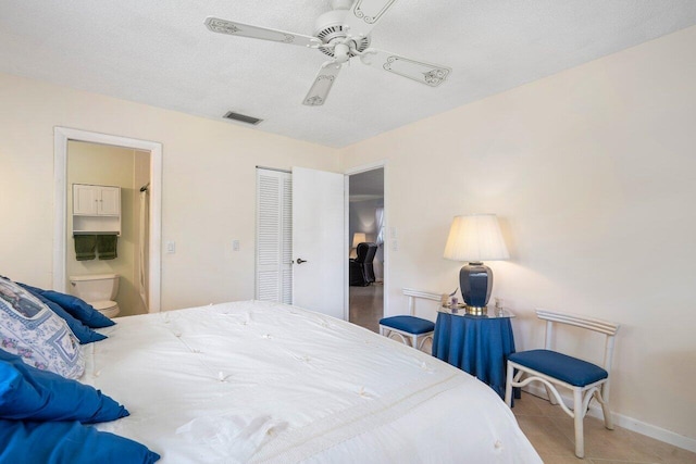 tiled bedroom with ceiling fan, a textured ceiling, a closet, and ensuite bathroom