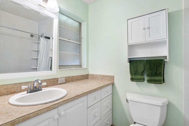 bathroom with backsplash, walk in shower, vanity, and toilet