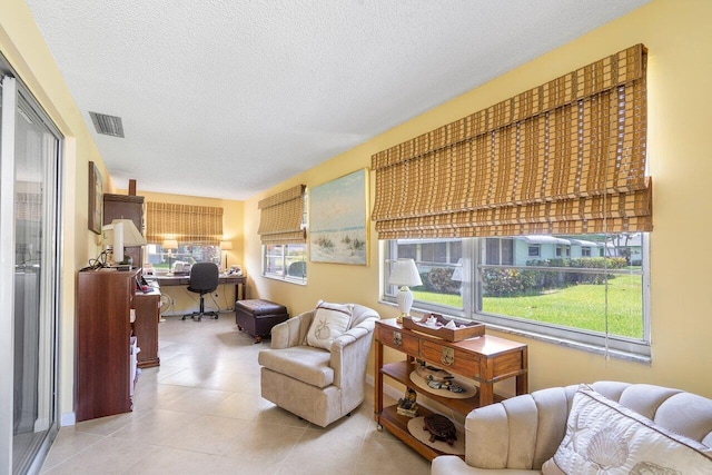 living room with a textured ceiling and light tile patterned flooring