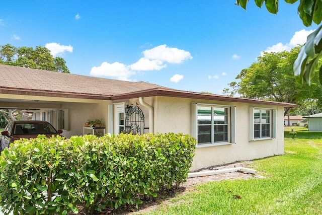 view of home's exterior with a lawn and a carport