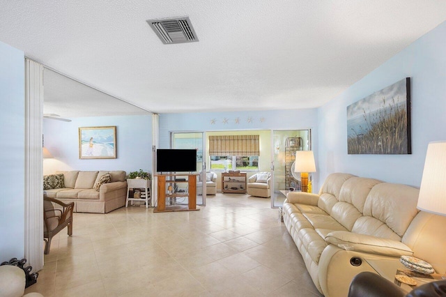 tiled living room featuring a textured ceiling