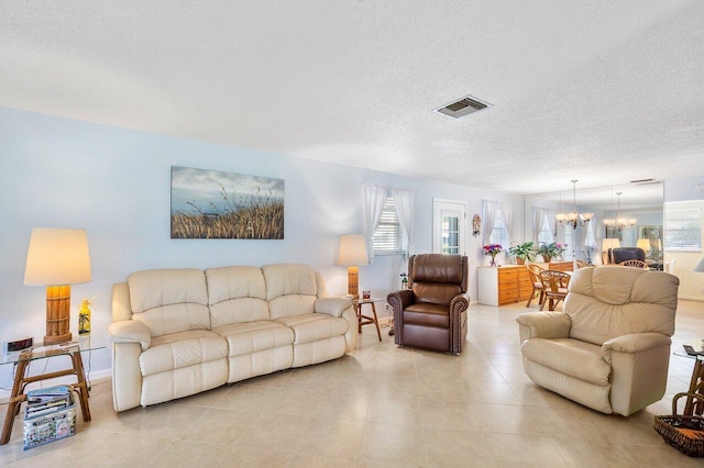 living room with a textured ceiling, a chandelier, and a wealth of natural light