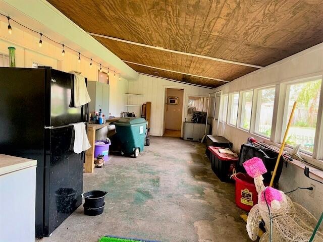 miscellaneous room with wooden ceiling, vaulted ceiling, and concrete flooring