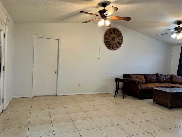 tiled living room with lofted ceiling, a textured ceiling, and ceiling fan