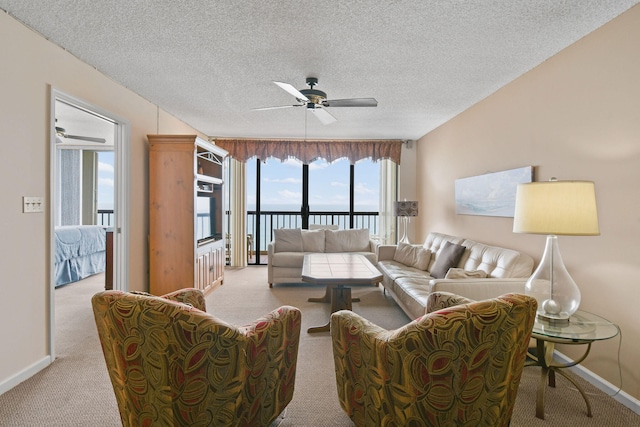 living room featuring carpet flooring, ceiling fan, and a textured ceiling