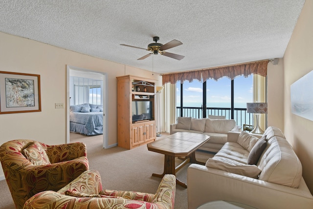 carpeted living room with ceiling fan and a textured ceiling