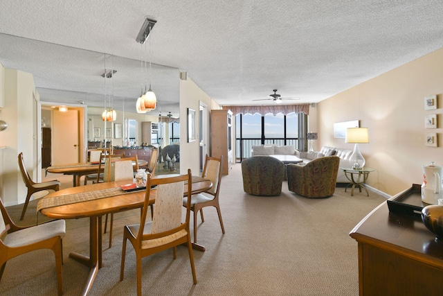 dining area featuring a textured ceiling, carpet flooring, and ceiling fan