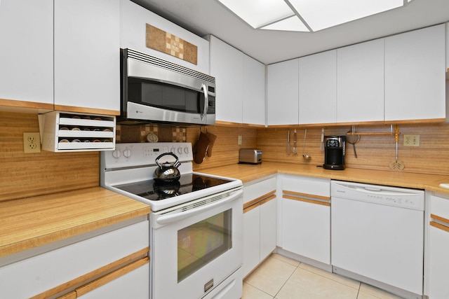 kitchen featuring white appliances, white cabinetry, and backsplash