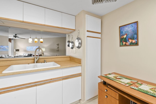 kitchen featuring sink, ceiling fan, decorative light fixtures, and white cabinetry