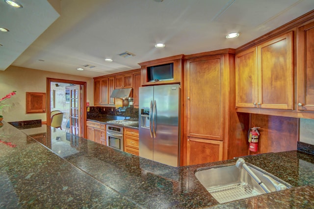 kitchen with appliances with stainless steel finishes, sink, and tasteful backsplash