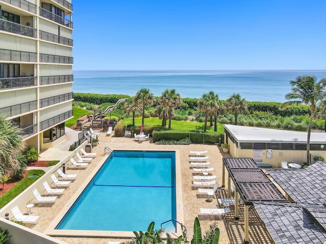 view of pool featuring a patio and a water view