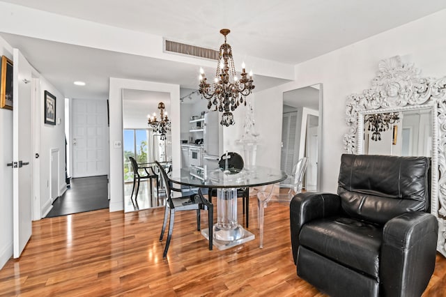 dining area featuring a chandelier, visible vents, and wood finished floors