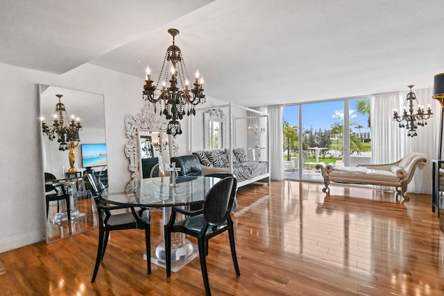 dining room with a notable chandelier, baseboards, a wall of windows, and wood finished floors