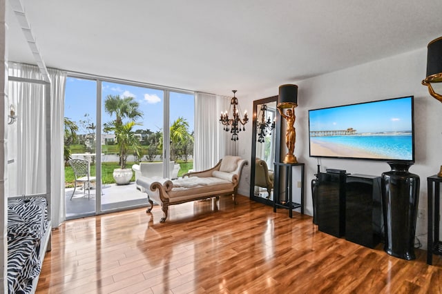 sitting room featuring plenty of natural light, an inviting chandelier, and hardwood / wood-style flooring