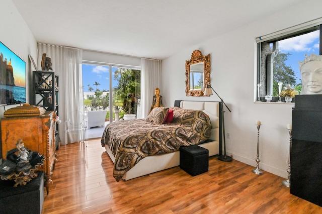 bedroom featuring access to exterior and hardwood / wood-style floors