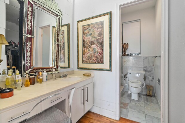 bathroom with vanity, tile walls, hardwood / wood-style flooring, and toilet