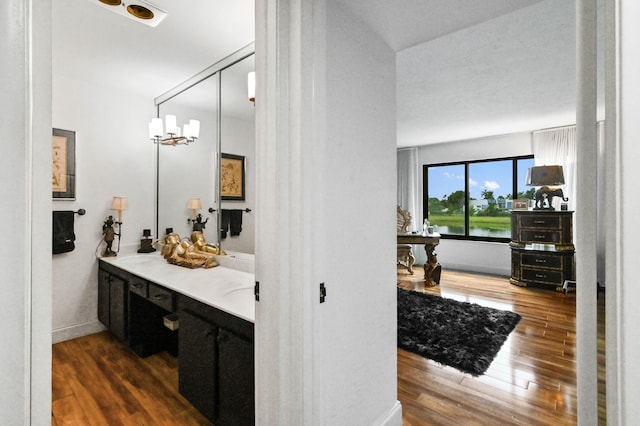 bathroom with vanity, an inviting chandelier, and wood-type flooring