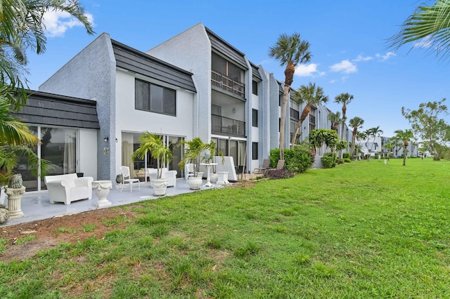 back of property with a patio, an outdoor hangout area, and a yard