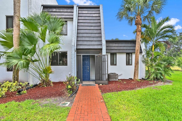 view of front of home featuring central AC and a front lawn