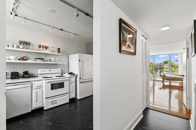 kitchen featuring decorative backsplash, dark hardwood / wood-style floors, track lighting, and white appliances