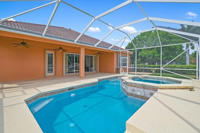 view of swimming pool with a pool with connected hot tub, glass enclosure, ceiling fan, and a patio