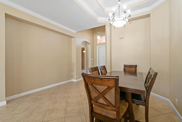 dining space with light tile patterned floors, arched walkways, a raised ceiling, and crown molding