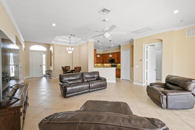 living room featuring arched walkways, light tile patterned floors, visible vents, and crown molding