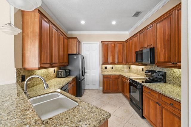 kitchen with a sink, visible vents, light stone countertops, black appliances, and brown cabinetry