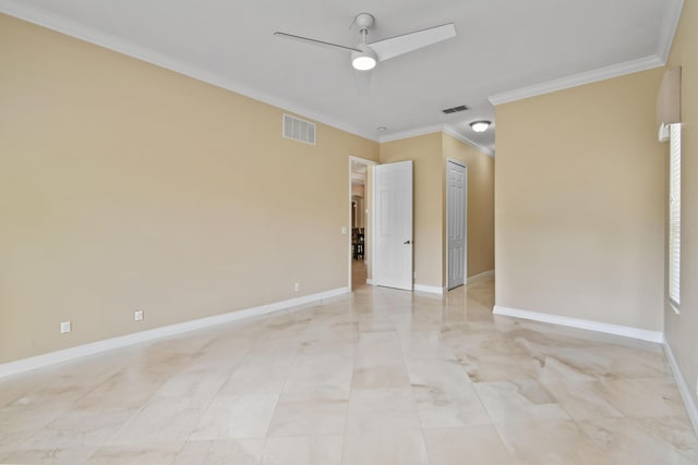 spare room with ornamental molding, visible vents, ceiling fan, and baseboards