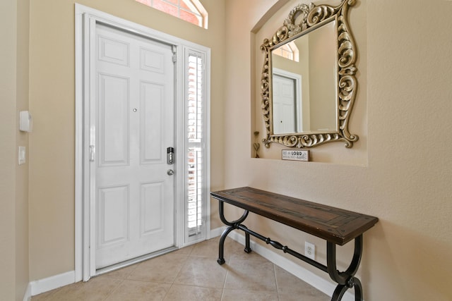 foyer featuring light tile patterned floors, plenty of natural light, and baseboards