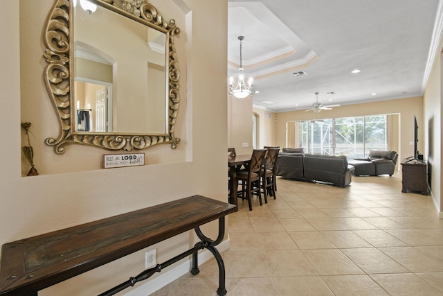 interior space featuring light tile patterned floors, ornamental molding, a raised ceiling, and visible vents