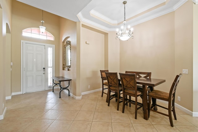 dining area featuring a healthy amount of sunlight, light tile patterned floors, arched walkways, and a tray ceiling